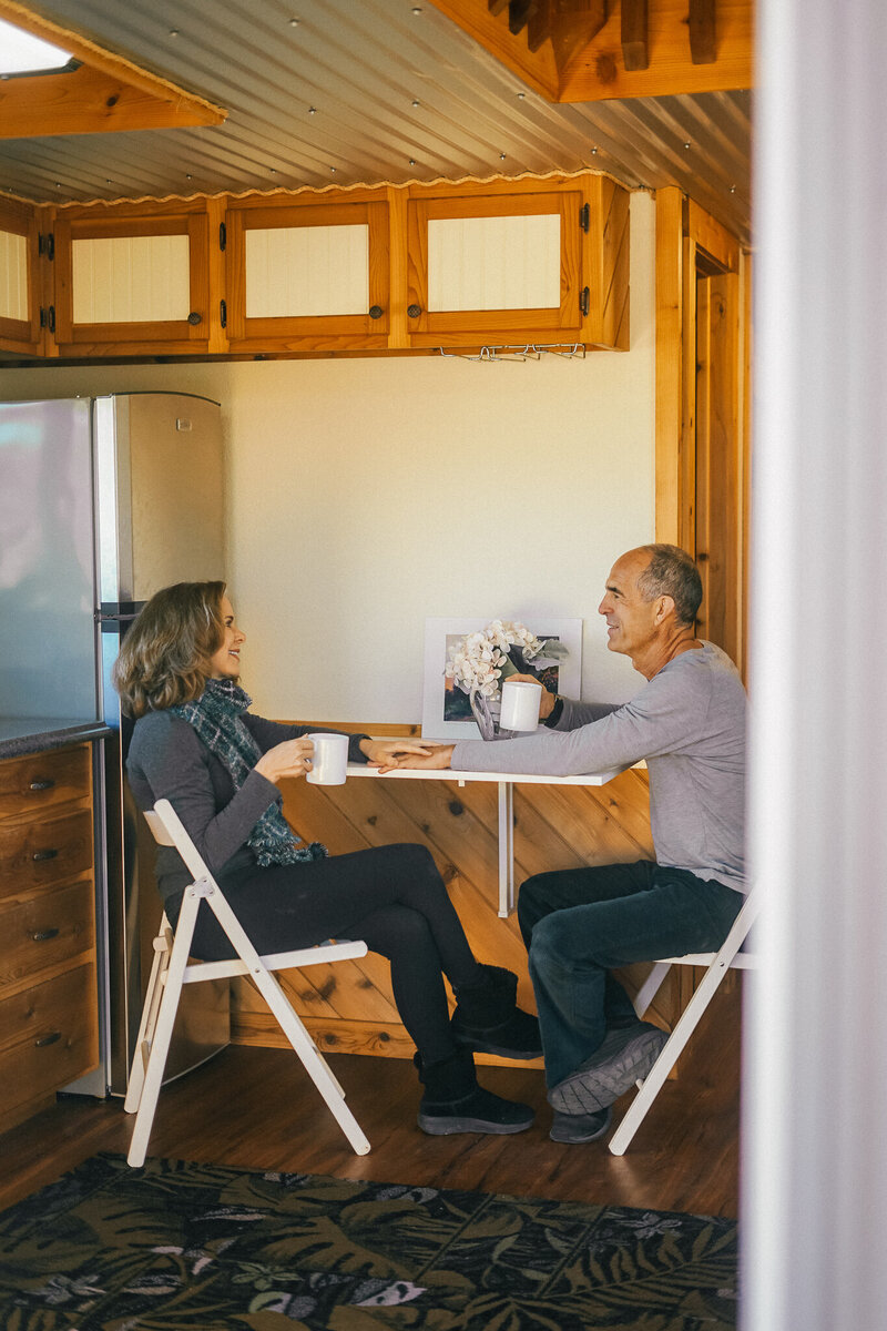 Man and woman drinking coffee at a small kitchen table