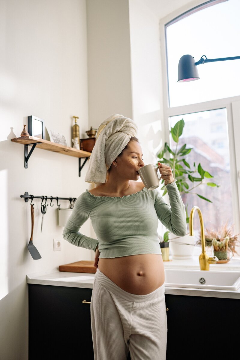Pregnant women standing in her kitchen