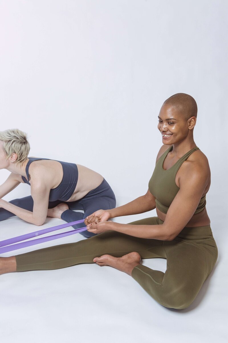 Two women stretching in Pilates studio
