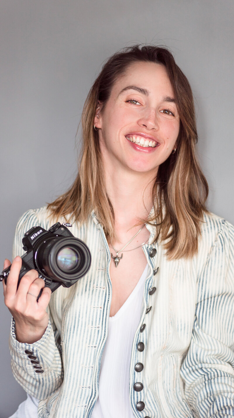 Jimena Adamec holding her camera and smiling