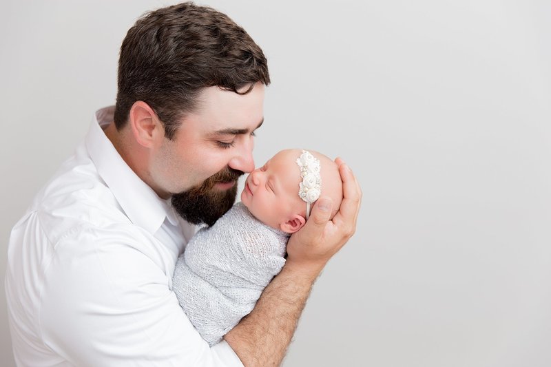 dad with newborn baby girl in greys and white