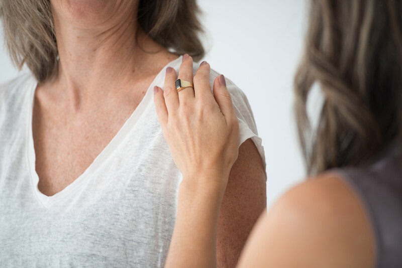 Woman's hand gently resting on another woman's shoulder