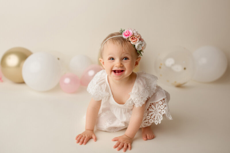 baby girl shappy and smiling during her birthday photo shoot