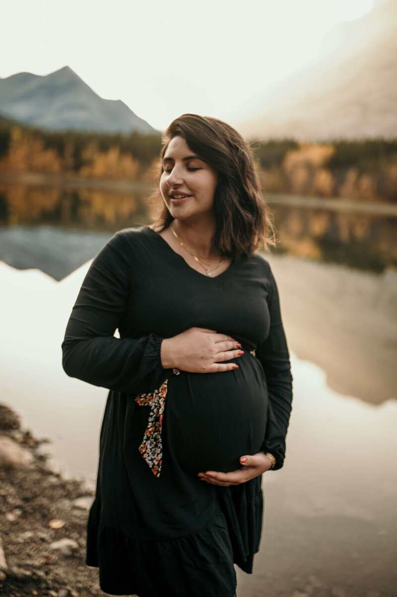 Pregnant woman in front of lake and mountains