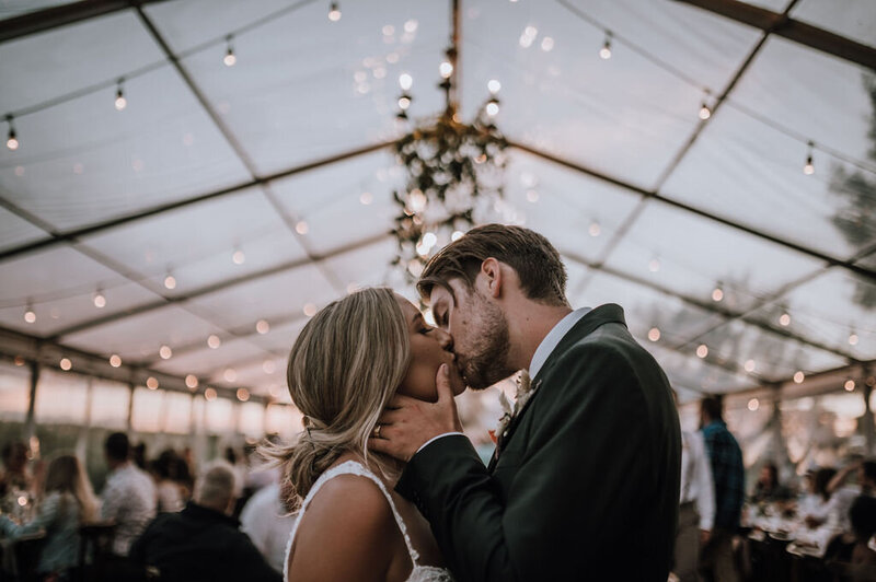 couple kissing in a clear tent at dusk