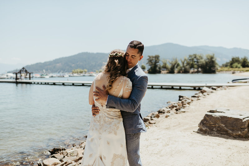 Couer d'Alene bride & groom embrace along waterfront