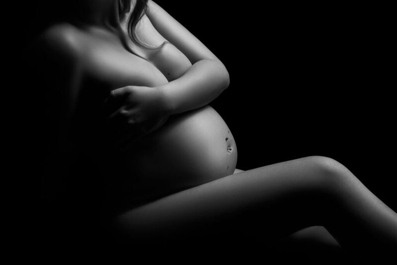 A closeup maternity bodyscape of a pregnant woman in black and white, captured by a photographer in Bemidji, Minnesota