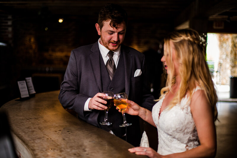 Bride and groom share a toast at the bar during their Quincy cellars wedding  reception