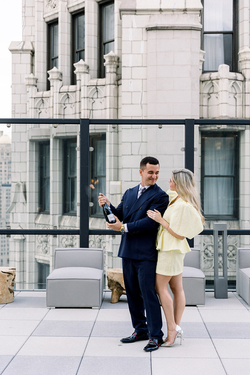groom popping champagne on chicago rooftop