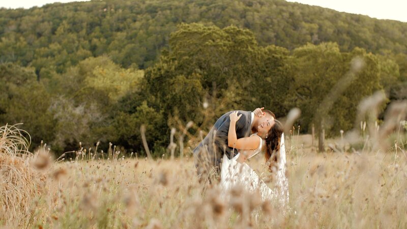 Newly married couple get married in a field