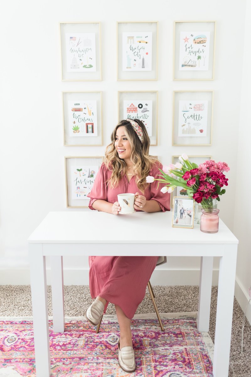 Female entrepreneur sitting at desk with a coffee mug and fresh flowers