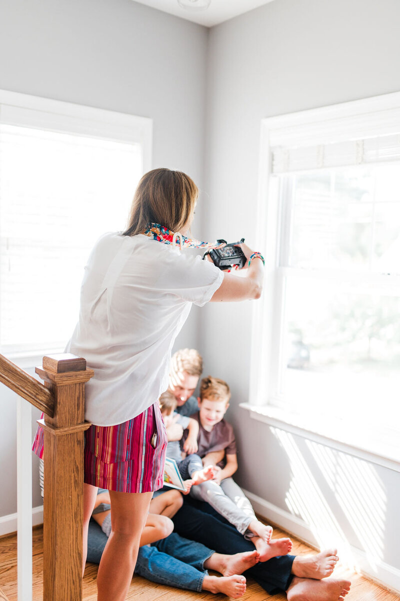 female photographer photographing a family at home