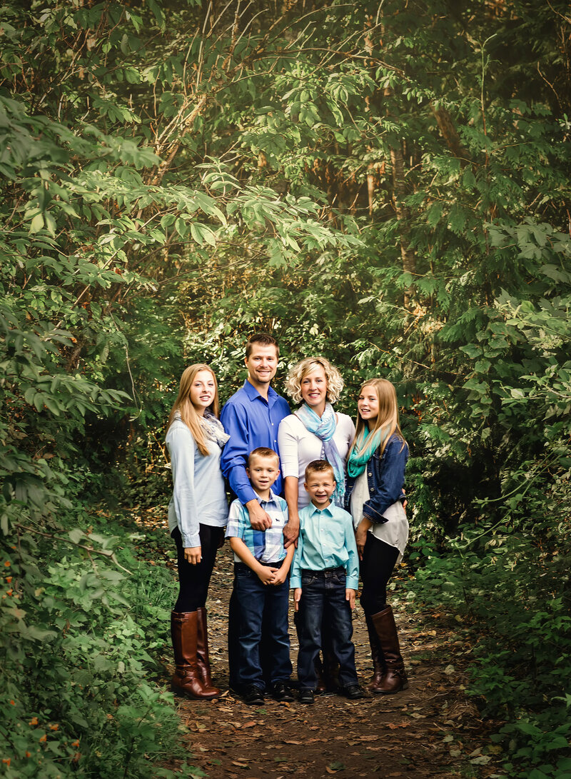 Family poses for portrait in a beautiful forest