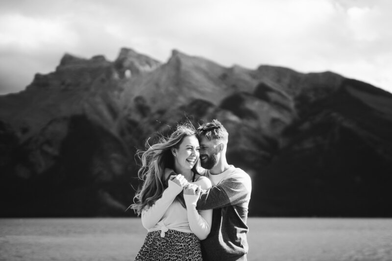 girls hair is blown by the wind in the mountains of banff for their engagement session