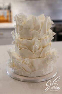 vertical wavy ruffle cake with miniature  sugar roses and fantasy  sugar leaves