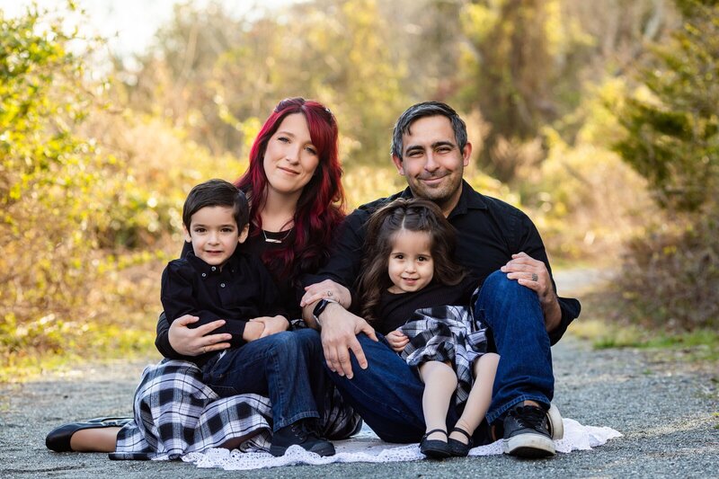 Family sitting on blanket in a park by family photographer nj