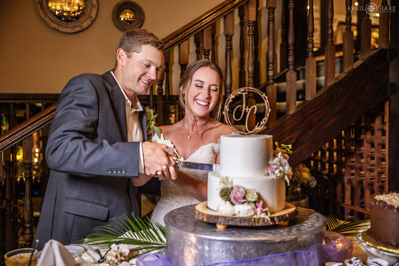 Couple Cut their Cake inside of Craftwood Peak Wedding Venue in Manitou Springs Colorado