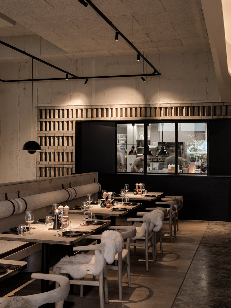 Sitzauswahl mit Blick in die offene Küche im Restaurant BRACA des Hotels the breeze.