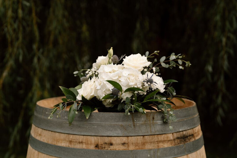 Rustic barn wedding decor green and white flowers wine barrel ceremony ideas