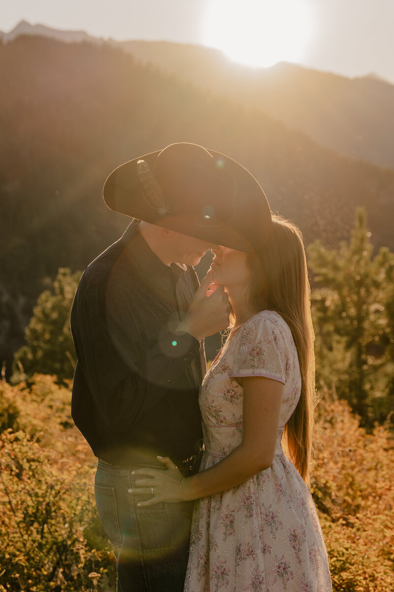 An engaged couple leans in for a kiss during golden hour in Leavenworth, Washington.