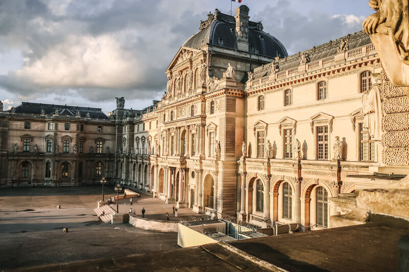 A large and impressive building, the front entrance to the Palais du Louvre in Paris