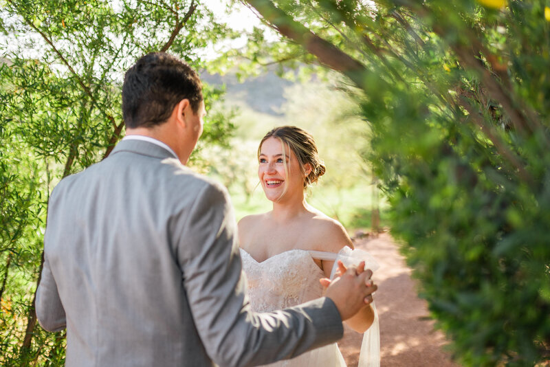 Bride and groom smile while they nuzzle into each other during their wedding portraits at Saguaro Buttes in Tucson, AZ.