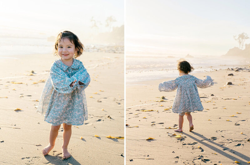 A little girl twirling in a light blue floral print dress on the beach in Malibu
