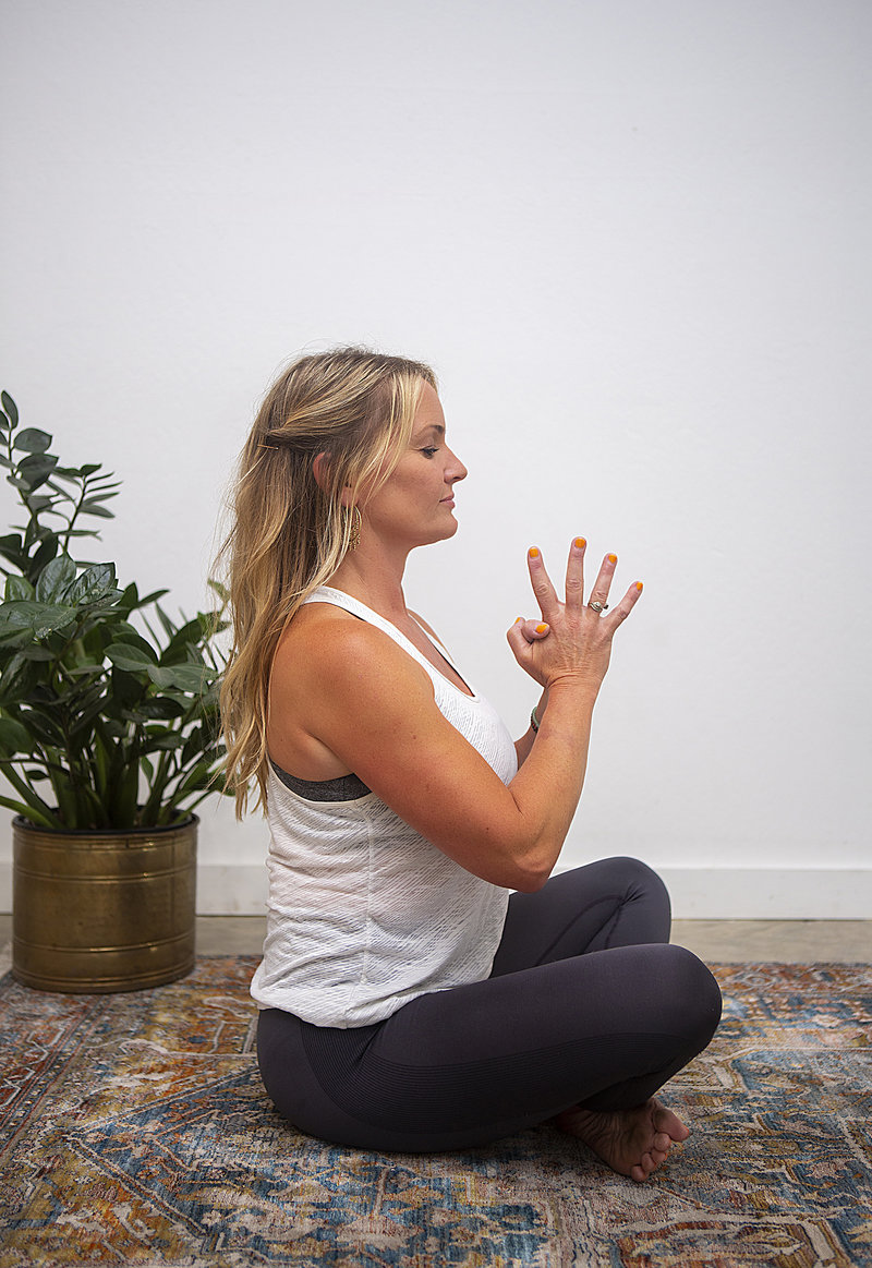 Profile view of female yoga student holding lotus prayer pose during yoga class at Hotsource Yoga in Aptos