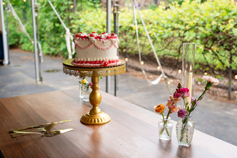 Chic & elegant outdoor wedding reception table with cake and flowers, photographed by wedding photographer Niko Coric - Lumen Clarity Media