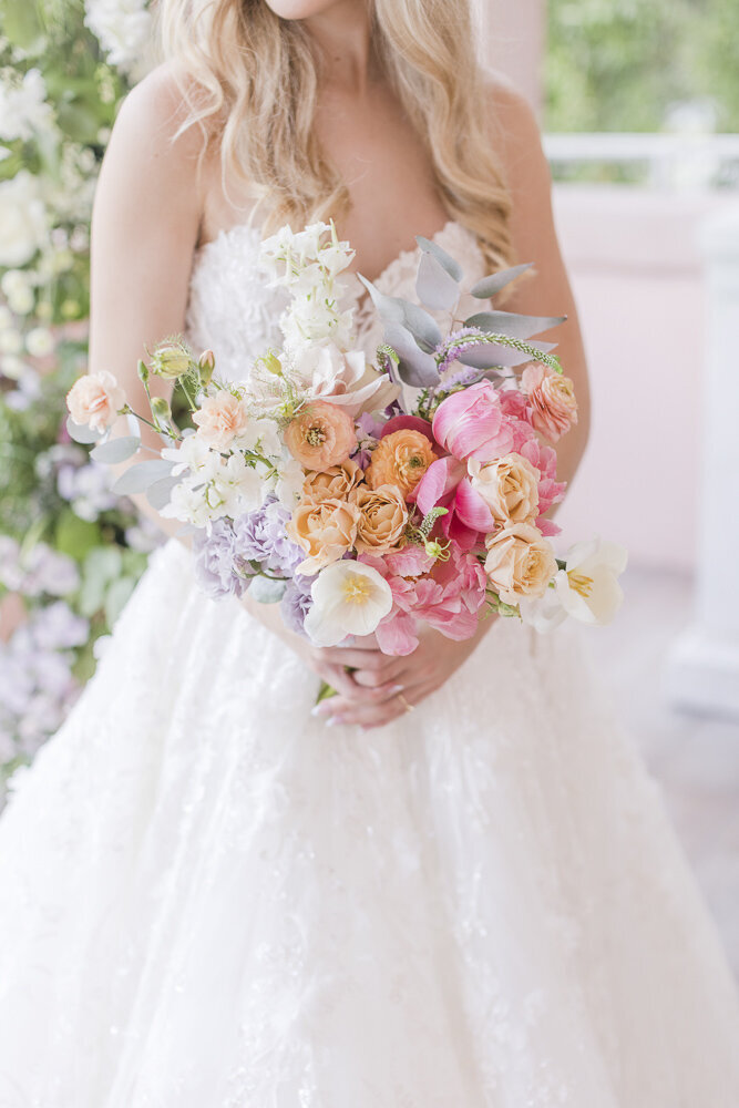 bride holding a colorful flower bouquet