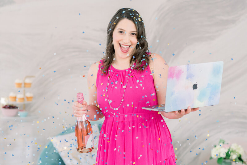 Isabel Kateman in a pink dress with confetti holding a laptop