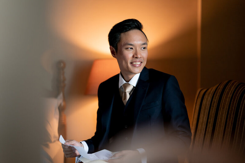 Groom smiling while holding his bride's letter