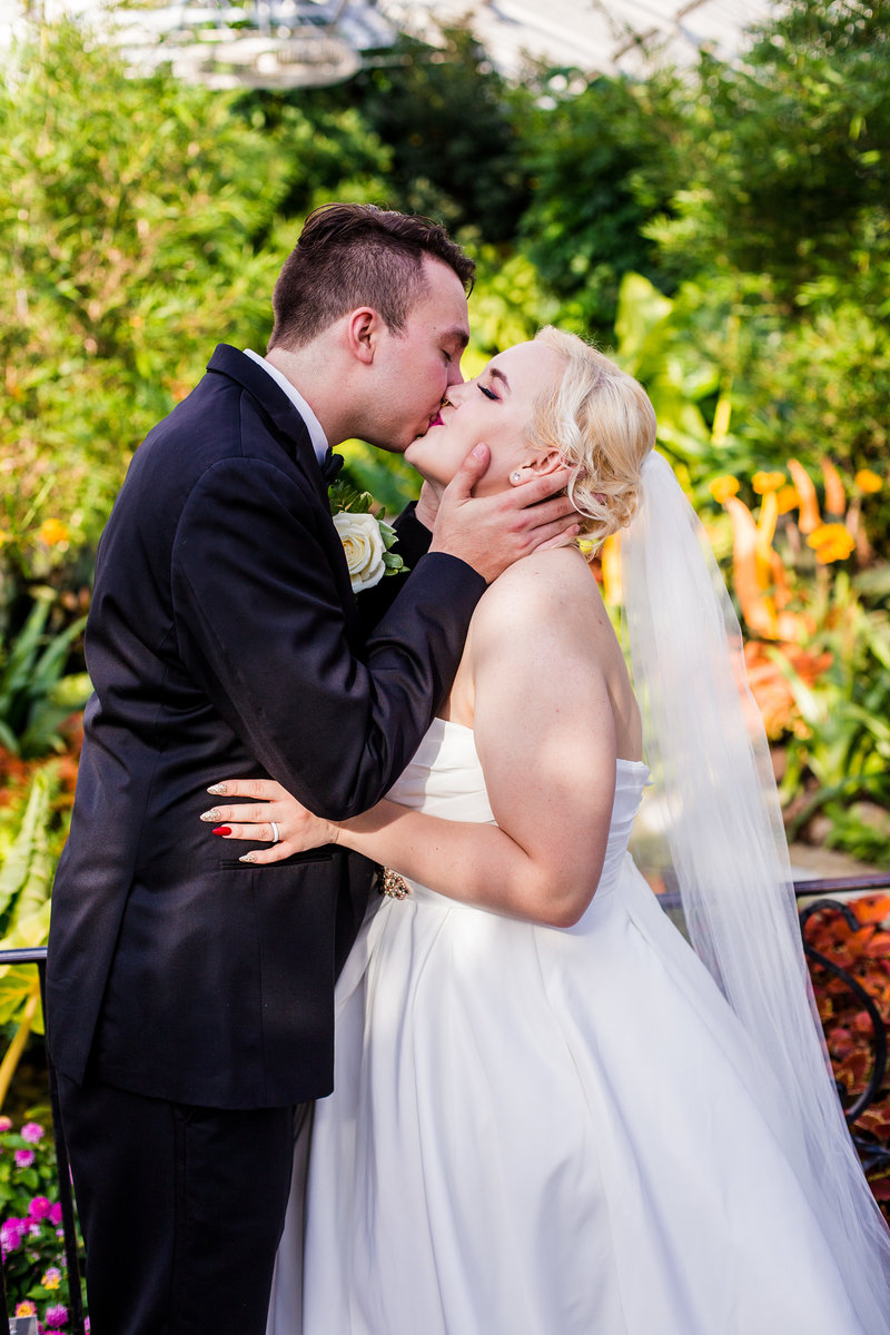 Bride and groom kissing in the Phipps Conservatory