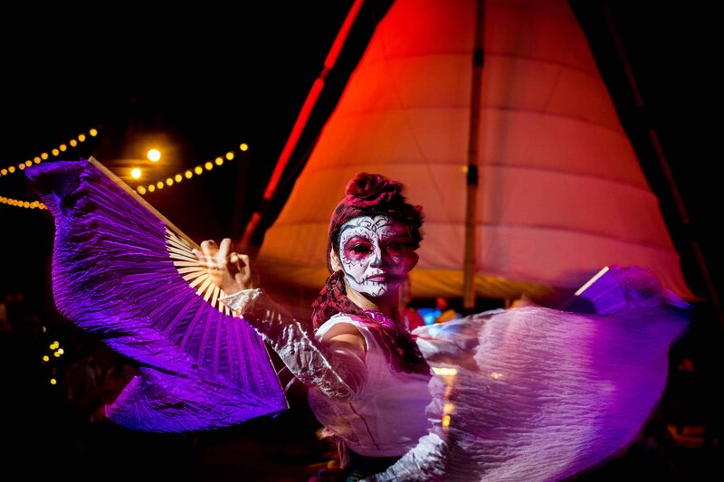 A dancer with 'day of the dead paint' and silk fans swirls at a corporate event reception in San Diego
