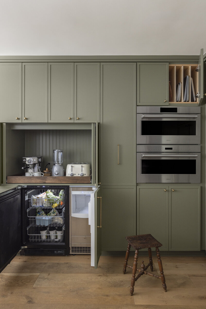 green skinny shaker kitchen cabinets with  a breakfast bar.