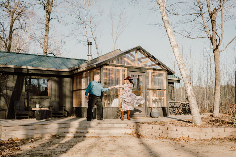 Couple swing dancing in front of a modern cabin in Northern Minnesota