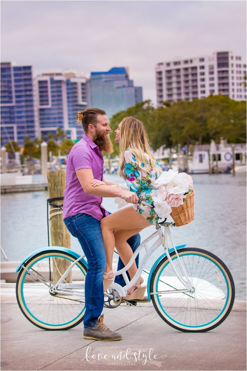 Adorable couple on a blue bike at Bayfront park with downtown Sarasota in the background