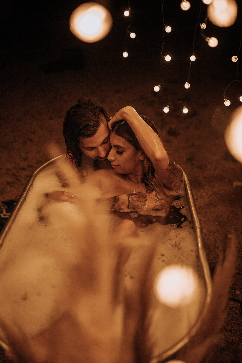 edgy tattooed couple boudoir session with twinkle lights