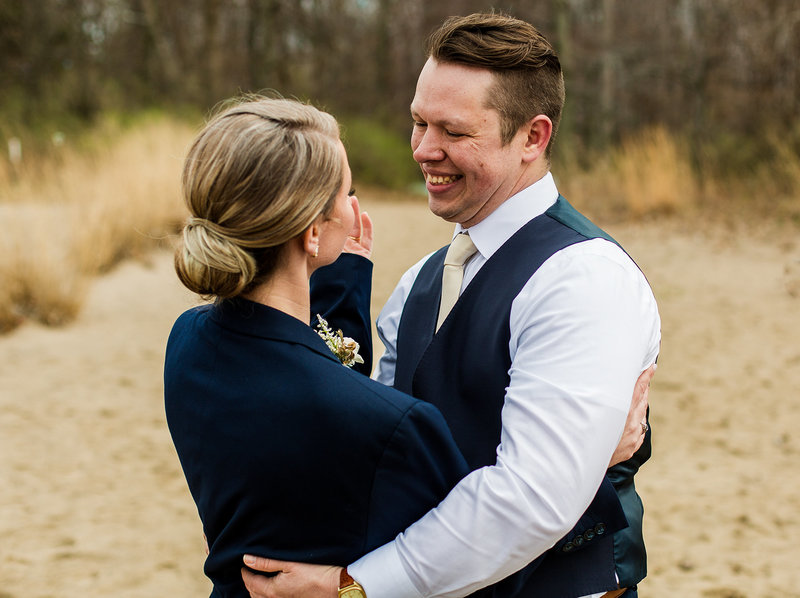 Groom smiles at bride after their Presque Isle Beach wedding