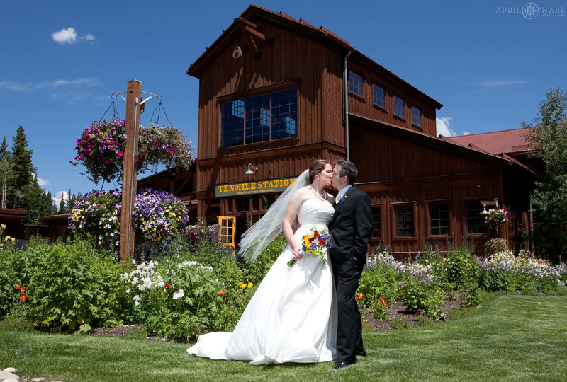 Couple pose for a wedding portrait on a bright sunny Colorado summer day outside of Ten Mile Station wedding venue in Breckenridge