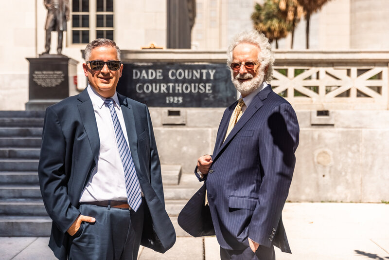 two men smiling in front of dade county courthouse