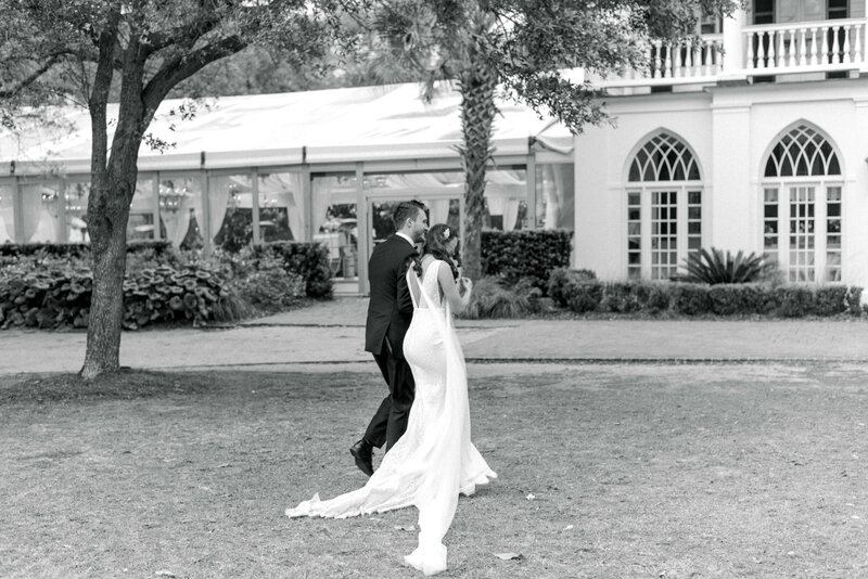 Bride and groom walking across the lawn at Lowndes Grove in Charleston South Carolina