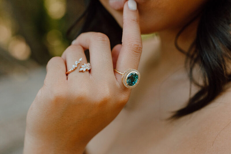 Bezel set blue zircon ring in 14k gold setting with natural diamond surround