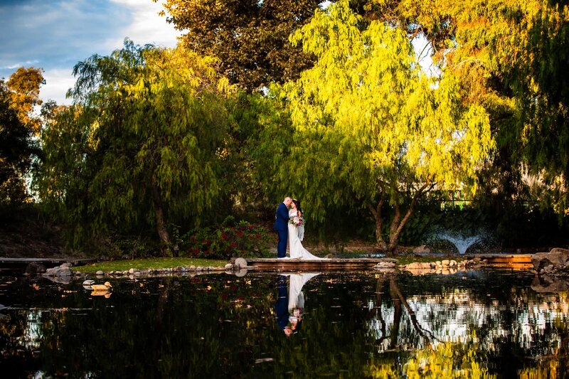 Bride and groom embracing by the lake at Galway Downs by Wedgewood Weddings in Temecula