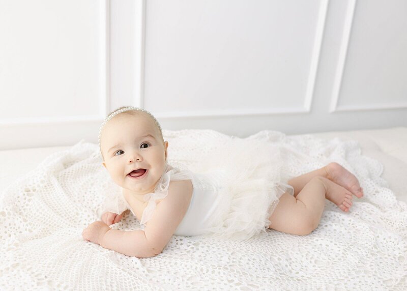Baby on tummy smiling at baby photographer nj