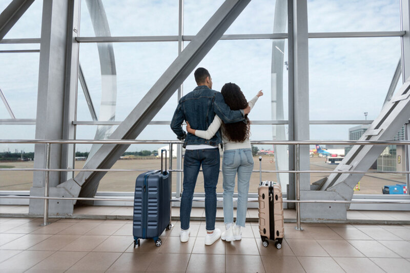 Couple inside the airport about to board a plane with their luggage
