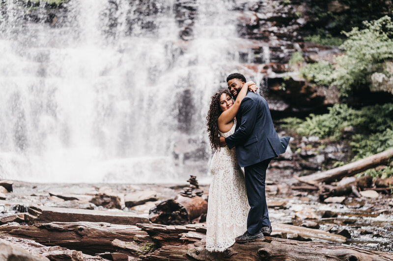 Couple hiking through Ricketts Glenn state park during their elopement.
