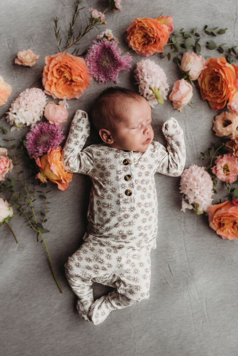 Newborn baby surrounded with flowers