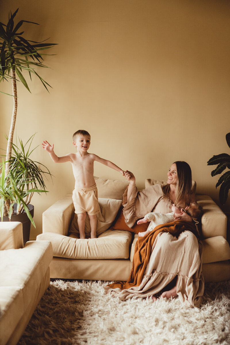 family jumping on sofa breast feeding motherhood new mummy