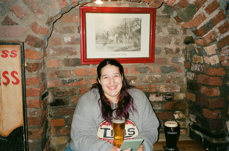 A person smiling while sitting in an old school pub